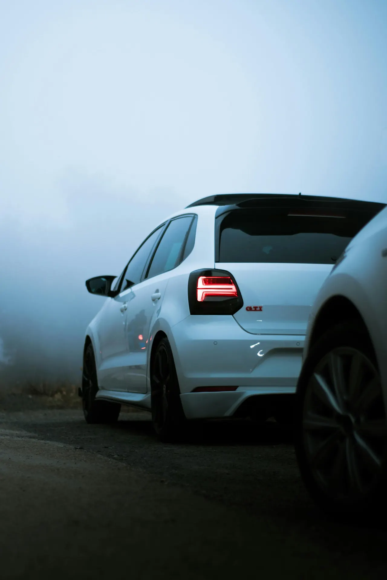 Белый Volkswagen Polo GTI — компактный автомобиль концерна Volkswagen — на дороге в тумане